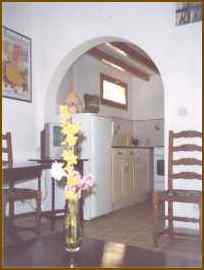 The dining area and kitchen through an arch